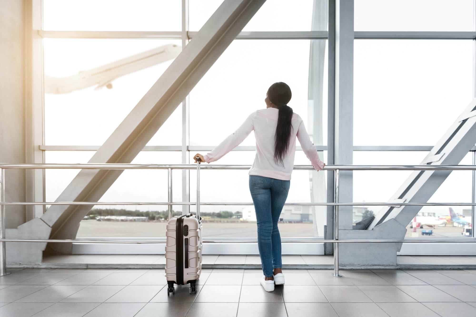 Air Transportation. Black Woman Looking At Plane While Waiting Flight In Airport