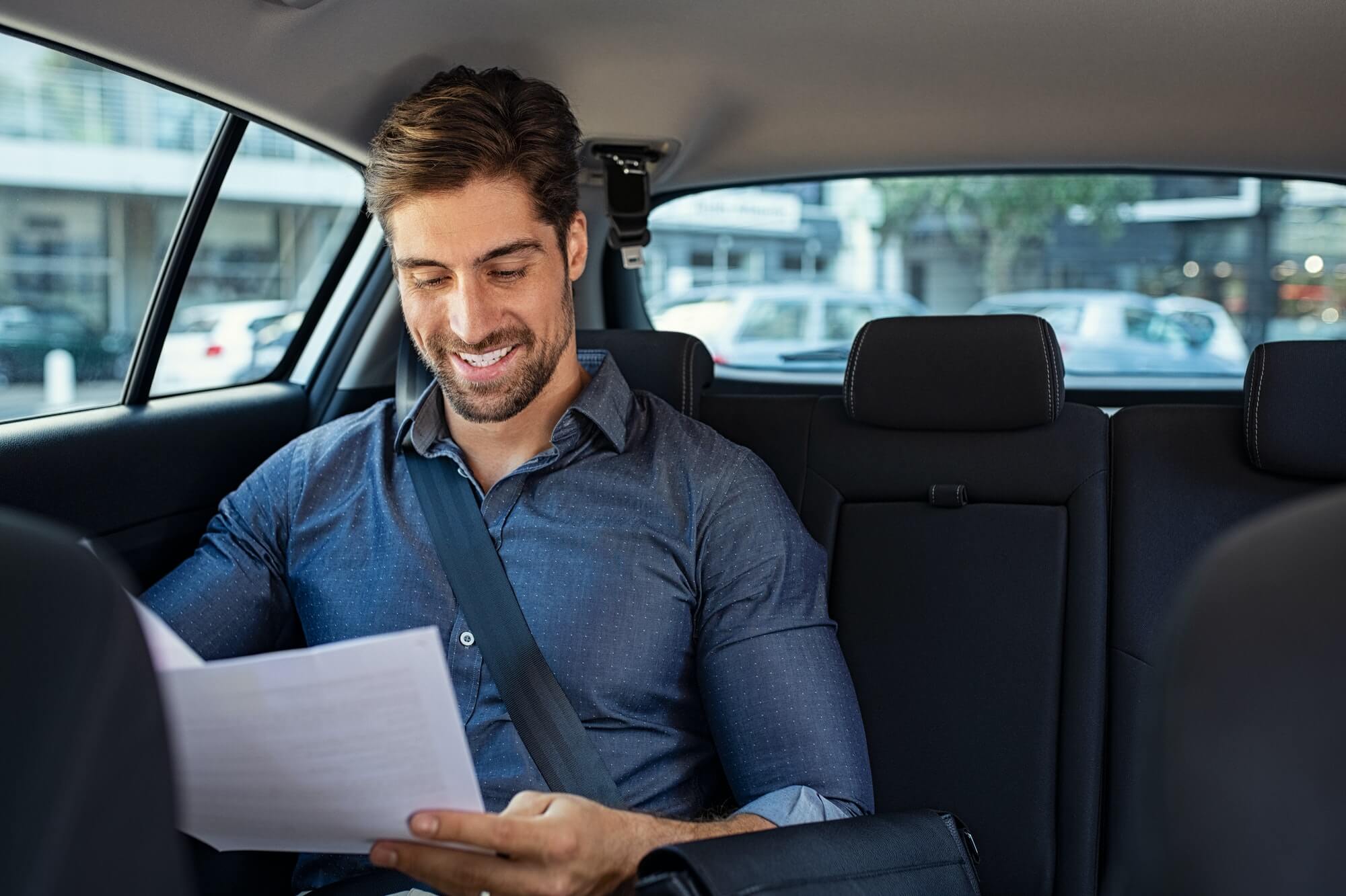 Businessman reading documents in car