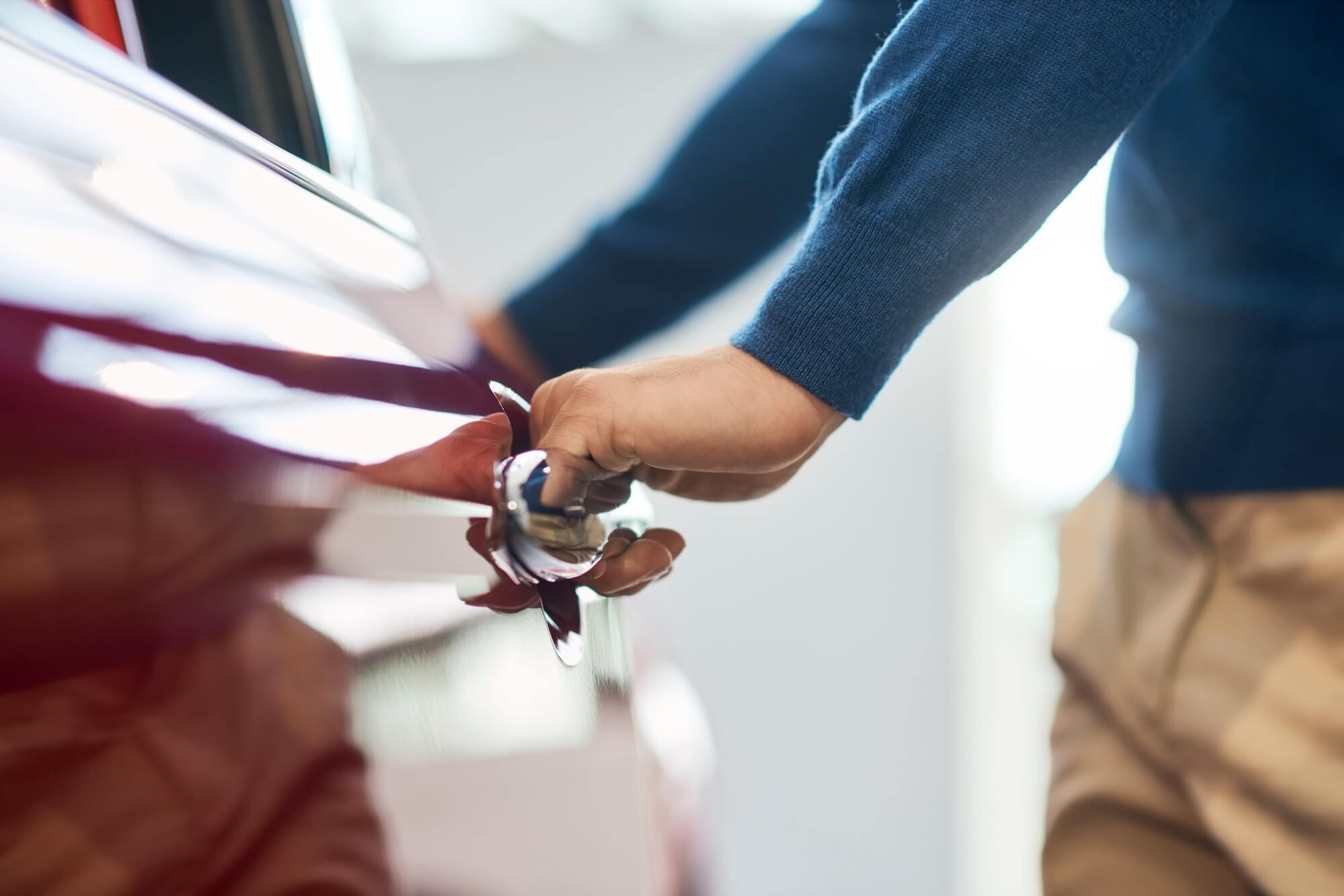 Hand of male businessman opening car door