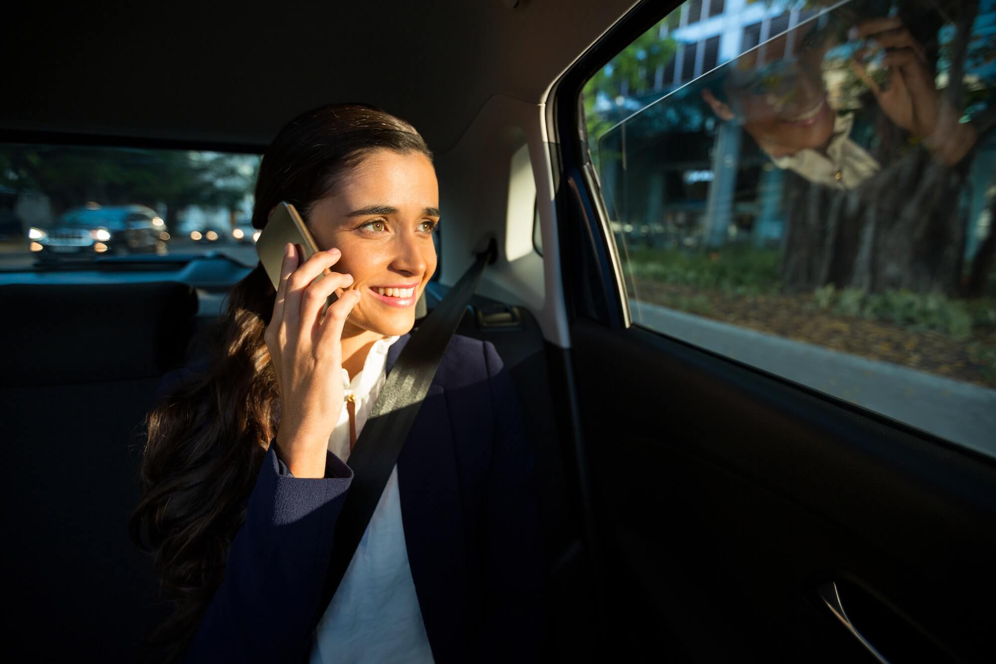 Business executive talking on mobile phone in car